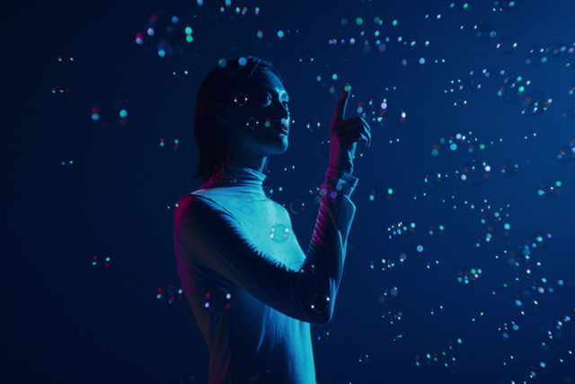 person standing and touching digital screen of dots